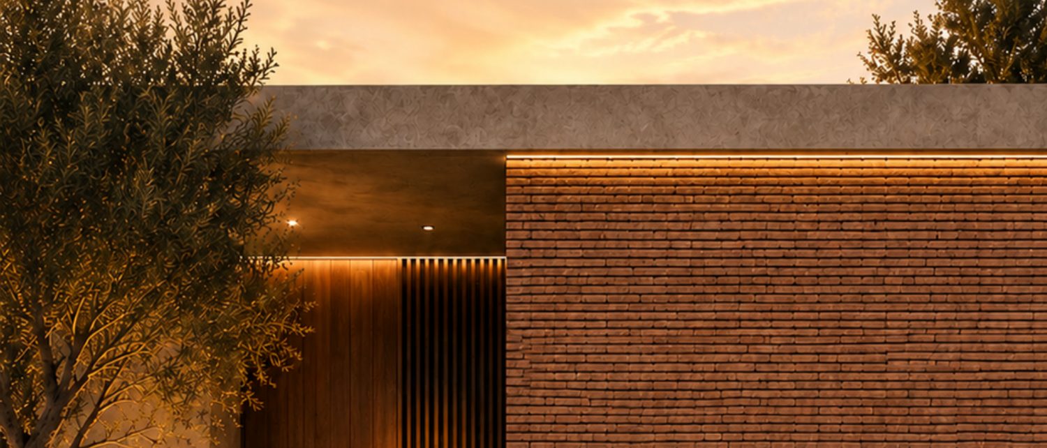 Fachada de ladrillo y madera al atardecer, portada del Catálogo Arquitectónico HAKÛ 2026
